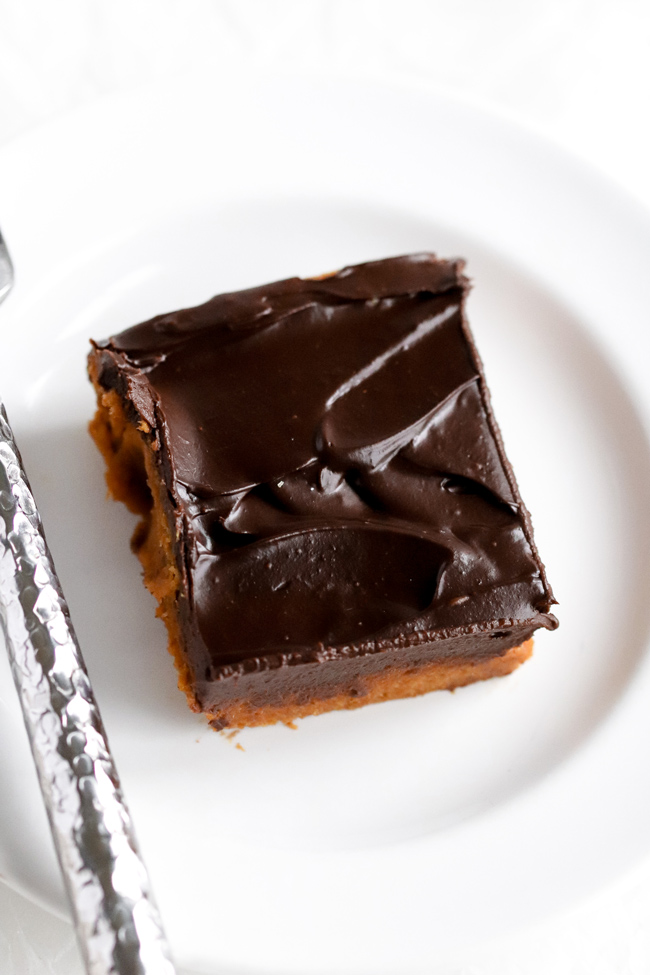 Chocolate-Frosted Paleo Pumpkin Brownies on a small plate with a hammered silverware fork.