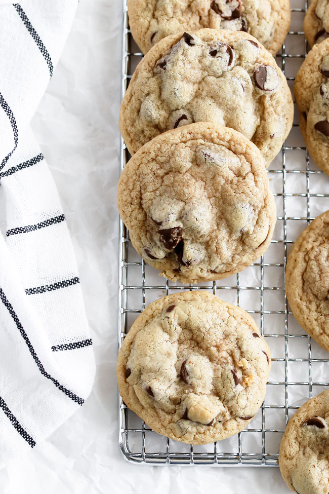 Gluten-free and dairy-free chocolate chips on a cooling rack next to a black and white-striped napkin.